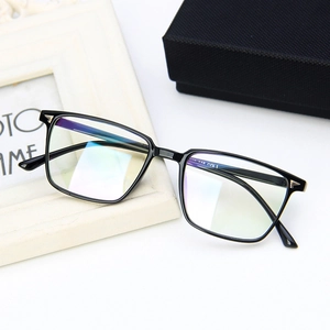 Close-up of black square eyeglass frames with polished finish on a white desk