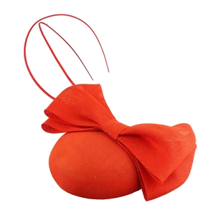 Macro detail of red fascinator hat featuring mesh bow and elegant feather accents