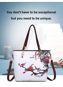 Detail of red plum blossom print and gold chain strap on a white tote handbag