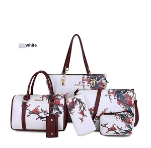 Detail of 6-piece handbag set featuring white faux leather and red floral pattern print