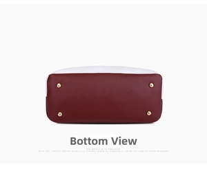 Detailed view of burgundy leather bag bottom with four protective gold metal feet studs