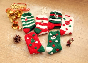 Detailed view of six Christmas coral fleece thermal socks displayed on wooden floor