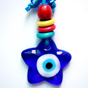 Detailed view of Turkish Evil Eye glass star pendant with colorful beads and blue cord