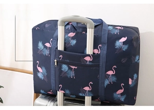 Foldable travel bag detail showing the back sleeve secured onto a silver suitcase handle