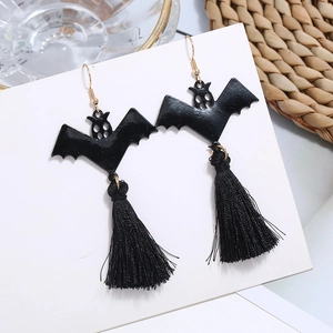 Halloween black bat tassel earrings with golden hooks on minimalist display background
