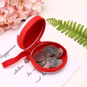 Red circular Christmas tin purse with zipper and strap, showing internal coin storage