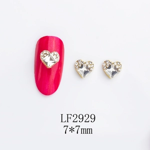 Detail view of 7x7mm heart nail charms with gold base and clear crystals for nail art