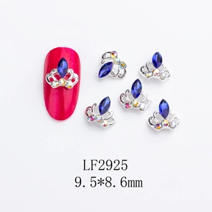 Detail of silver crown nail art charms with blue gems for professional manicures