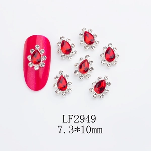 Macro view of crown-shaped red alloy nail charms with K9 crystals and teardrop stones