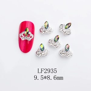 Silver crown nail art charm with K9 rhinestones and iridescent stone on red manicure