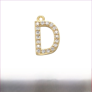 Detailed close-up of gold plated brass letter D pendant with micro-pave cubic zirconia
