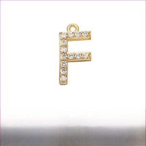Detailed view of gold-plated brass letter F pendant with micro-pave cubic zirconia stones