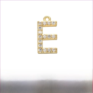 Macro view of gold-plated brass pendant letter E with micro-pave cubic zirconia stones