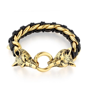 Detailed close-up of double wolf heads in gold on black braided leather bracelet for men
