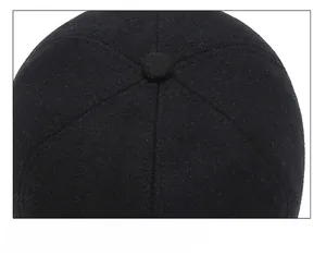 Close-up of black wool baseball cap top showing stitching detail and button