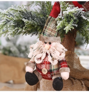 Plaid Christmas plush gnome ornament hanging on a snowy tree for festive holiday decor