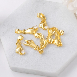 Golden palm charms with rhinestones on white marble display for DIY jewelry making