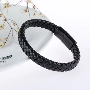 Dettaglio di bracciale in pelle nera intrecciata da uomo con chiusura magnetica cilindrica