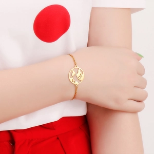 Minimalist gold world map cutout bracelet worn on wrist for a stylish fashion look