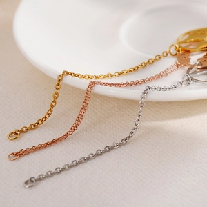 Minimalist map charm bracelet in gold, rose gold, and silver finishes on a ceramic plate
