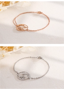 Detail of world map pendant bracelet in rose gold and silver on textured background
