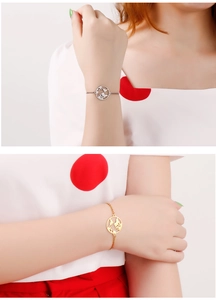 Detailed view of hollow world map charms on gold and silver stainless steel bracelets
