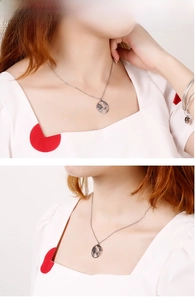 Detailansicht der silbernen Weltkarten-Halskette mit Anhänger am Model und passendem Armband