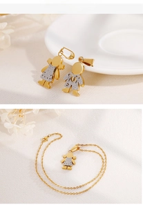 Dettaglio macro dei ciondoli bimbo e bimba placcati oro 18k con finitura argento