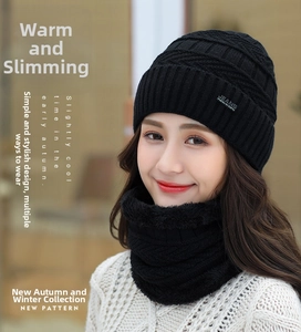 Close-up of black ribbed knit beanie with JEANS label and matching thick winter scarf set