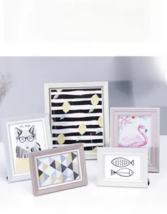 Modern Nordic photo frame set featuring minimalist art illustrations on a white desk