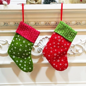 Set of 2 Christmas stockings with snowflake patterns hanging on white fireplace mantle