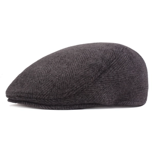 Detail shot of charcoal grey herringbone fabric texture on classic newsboy beret hat