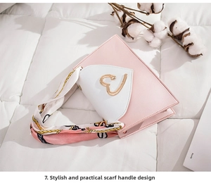Detail of pink and white crossbody bag with heart buckle and silk scarf handle