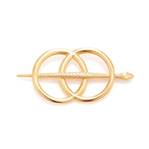 Macro detail of golden snake-shaped hair pin with scale texture and interlocking metal rings