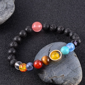 Bracelet huit planètes du système solaire avec perles de lave noire sur pierre grise