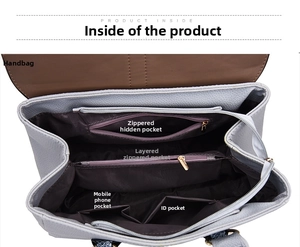Detail view of large tote interior showing multiple zip pockets and snake print handles