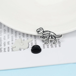 Detail view of T-Rex dinosaur skeleton enamel brooch with black rubber clutch backing