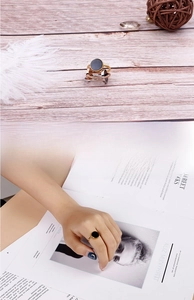 Close-up of stacked gold, silver and rose gold stainless steel rings on hand