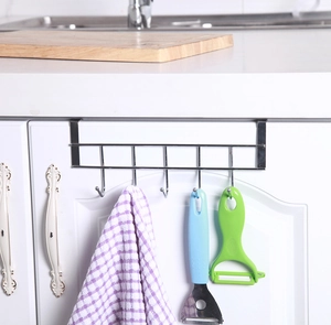 Detail of over-door stainless steel rack with 5 hooks holding towels and kitchen tools