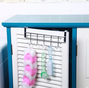 Detail of 5-hook stainless steel rack hanging over cabinet door with home accessories