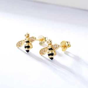 Detailed macro view of S925 silver bee stud earrings with gold plating and crystals