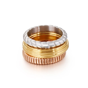Three-tone stackable rings in silver, gold, and rose gold with varied textures on white