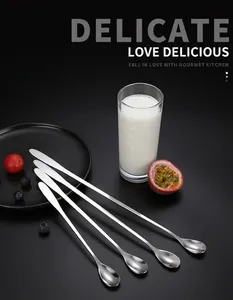 Close-up of four polished stainless steel long-handled spoons for coffee and desserts