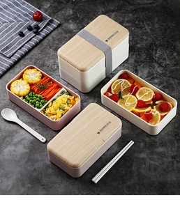 Detailed view of stackable Japanese bento box with wood-style lids and elastic strap