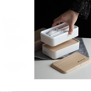 Detail of double-layer Japanese bento box featuring wood grain lid and built-in cutlery storage
