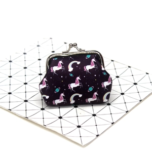 Close-up of a purple fabric coin purse with unicorn prints and silver metal clasp