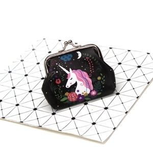 Detail of unicorn print coin purse with silver metal clasp on faux leather surface