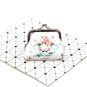 Detail of unicorn coin purse with metal clasp on black and white geometric board