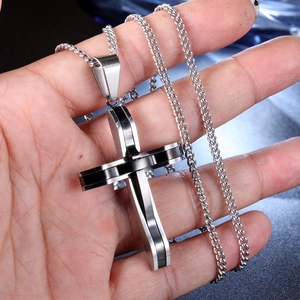 Close-up of a silver and black double-layered stainless steel cross pendant necklace