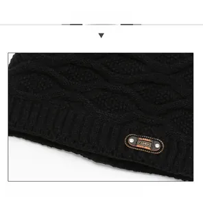 Detailed view of black knitted wool beanie with wavy texture and leather brand patch